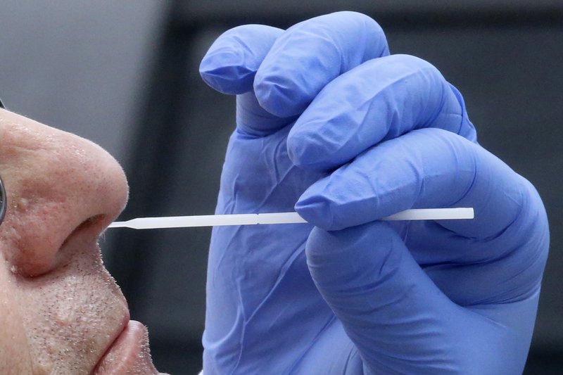 FILE - In this Friday, June 12, 2020 file photo, a nurse uses a swab to perform a coronavirus test in Salt Lake City. Months into the outbreak, no one really knows how well many of the screening tests work, and experts at top medical centers say it is time to do the studies to find out. (AP Photo/Rick Bowmer)