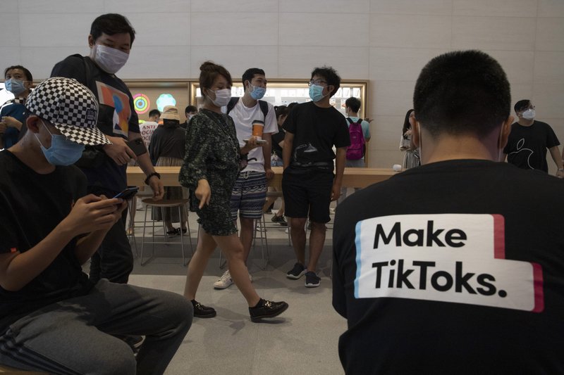 A visitor to an Apple store wears a t-shirt promoting Tik Tok in Beijing on Friday, July 17, 2020. U.S. President Donald Trump on Thursday, Aug 6, 2020 ordered a sweeping but unspecified ban on dealings with the Chinese owners of consumer apps TikTok and WeChat, although it remains unclear if he has the legal authority to actually ban the apps from the U.S. (AP Photo/Ng Han Guan)