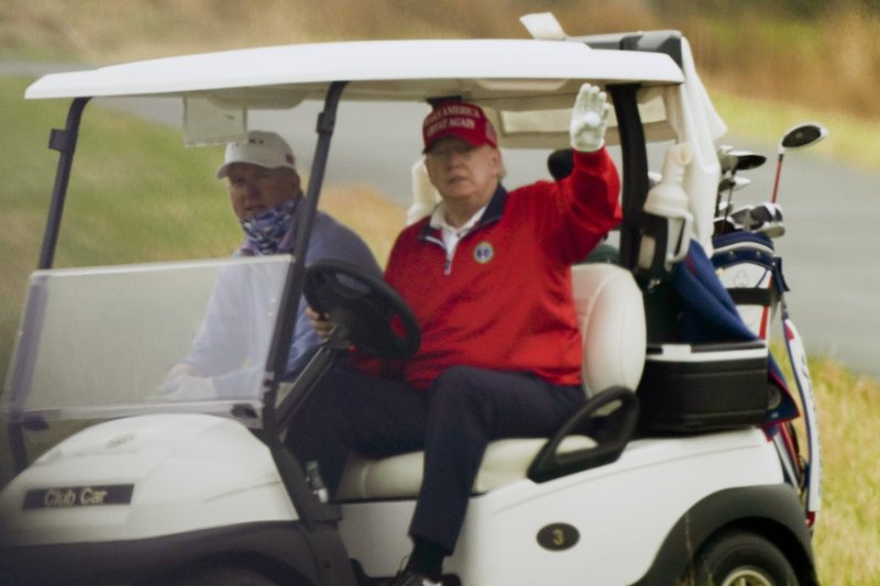 President Donald Trump waves from a golf cart as he plays golf at Trump National Golf Club, Friday, Nov. 27, 2020, in Sterling, Va. (AP Photo/Alex Brandon)