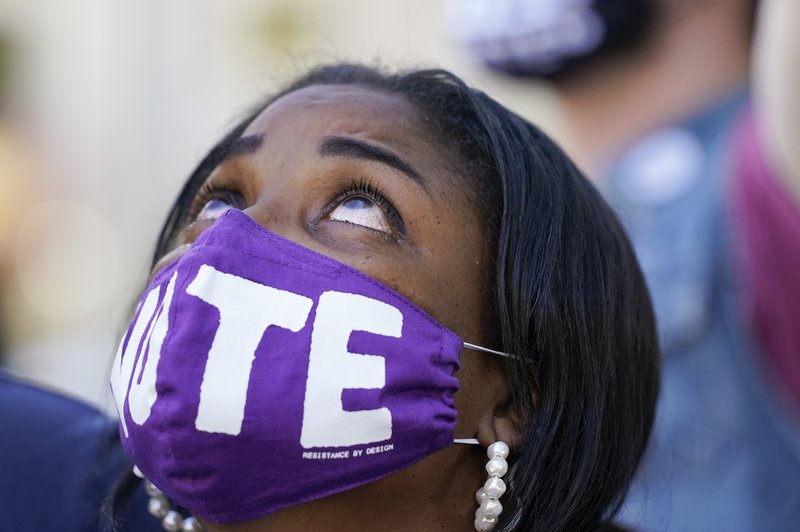 Janice Jamison, Evans, Ga, reacts after hearing the announcement by CNN that former vice president and Democratic presidential candidate Joe Biden had defeated Pres. Donald Trump, Saturday, Nov. 7, 2020, at McPherson Square in Washington. (AP Photo/Alex Brandon)