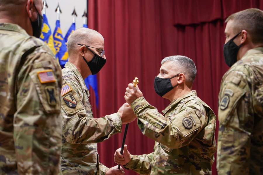 Command Sgt. Major Clifford Ockman Jr. receives the Noncommissioned Officer Sword from Brig. Gen. D. Keith Waddell, adjutant general of the Louisiana National Guard, signifying the assumption of responsibility as the senior enlisted leader of the entire LANG at the Camp Beauregard post theater in Pineville, La., Dec. 6, 2020. (U.S. Army National Guard photo by Sgt. 1st Class Denis B. Ricou)