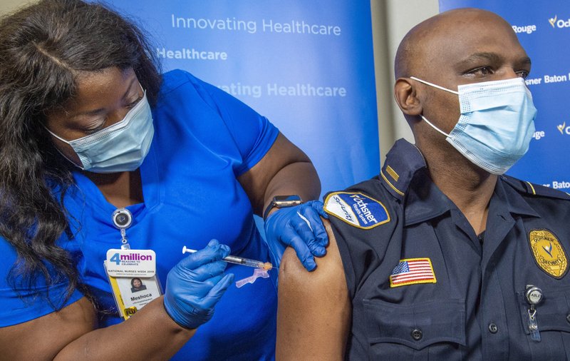 Lt. Ollie Martin, right, with Ochsner Security, is inoculated with the Pfizer-BioNTech COVID-19 vaccine by nurse Meshoca Williams at Ochsner Hospital on O'Neal Lane, Tuesday, Dec. 15, 2020, in Baton Rouge, La. (Bill Feig/The Advocate via AP, Pool)