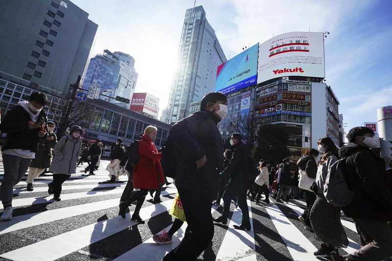 People wearing protective masks to help curb the spread of the coronavirus walk along pedestrian crossings Monday, Jan. 25, 2021 in Tokyo. The Japanese capital confirmed more than 600 new coronavirus cases on Monday. (AP Photo/Eugene Hoshiko)