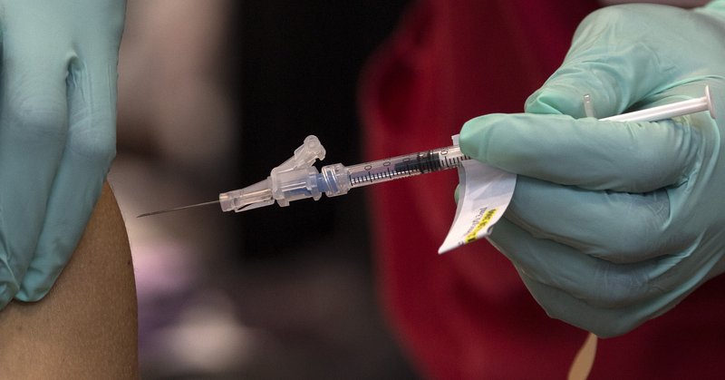A staff member with the Southeast Louisiana Veterans Health Care System receives a shot with the first batch of Pfizer Inc.'s coronavirus vaccine in New Orleans, Monday, Dec. 14, 2020. (Max Becherer/The Advocate via AP)