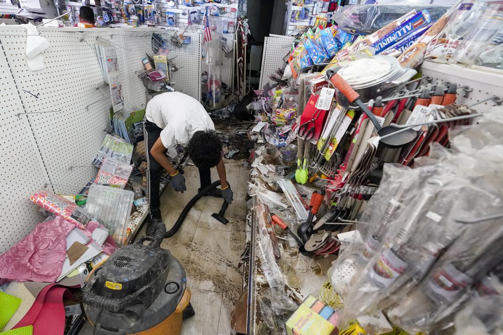 FILE - In this Sept. 4, 2021 file photo, a worker uses a heavy duty vacuum cleaner to collect flood water off the floor of the Dollar Depot store after remnants of Hurricane Ida inundated the community, in Mamaroneck, N.Y. Small businesses from Louisiana to Connecticut are facing an uncertain recovery after being walloped by Ida and its residual rains and flooding last week. Days after the destruction, they’re reaching out to clients and staff, assessing damage and trying to plan for the way forward. (AP Photo/Mary Altaffer, File)